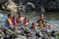 a Guatemalan family swimming in a river
